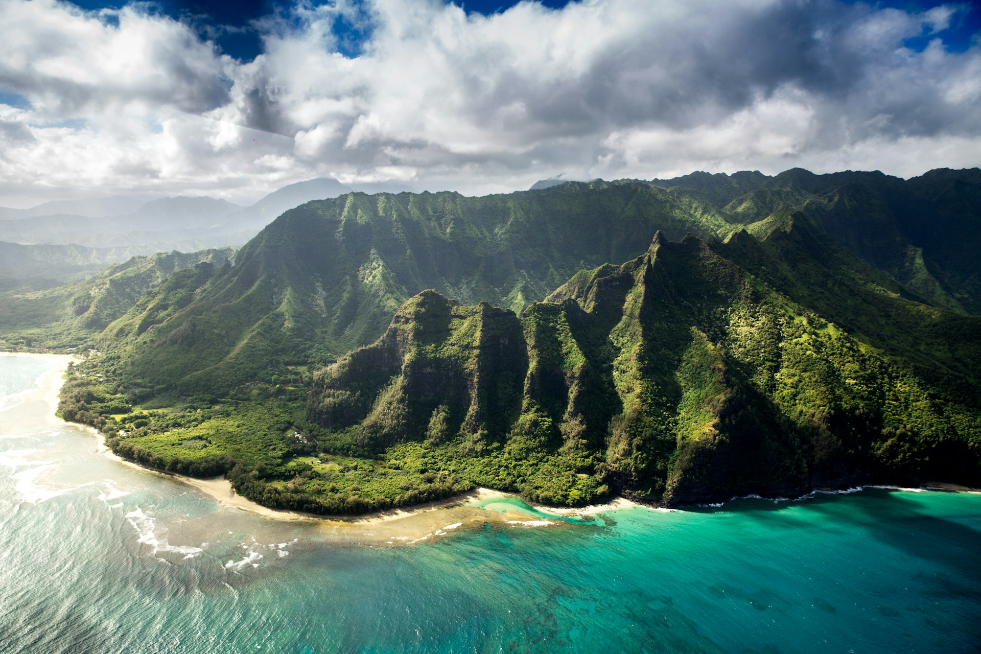 Aerial view of green mountain beside ocean in Hawaii